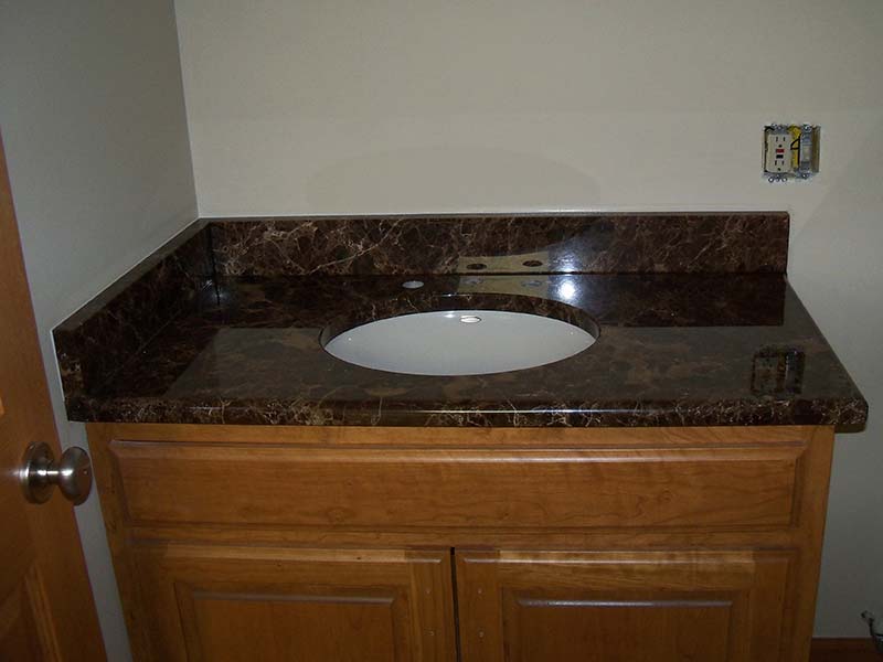 Emperador Dark Marble bathroom counter over medium toned bathroom vanity.