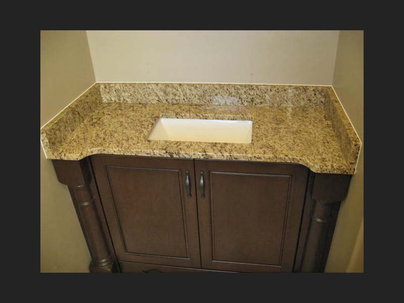 Giallo Ornamental Granite bathroom counter over a dark wood vanity with a square sink.