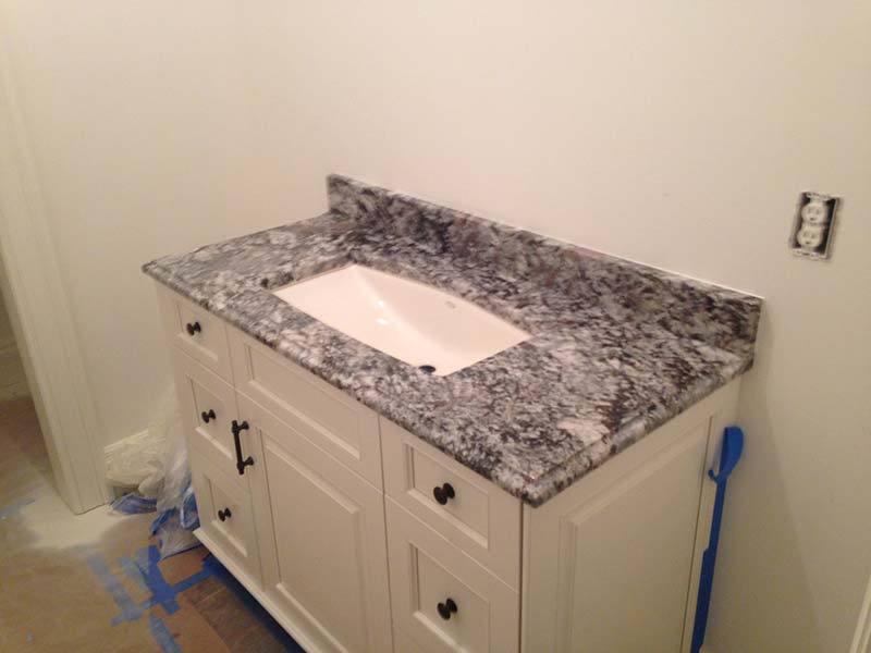 This Lennon Granite bathroom counter provides some dark contrast in this light colored bathroom. 
