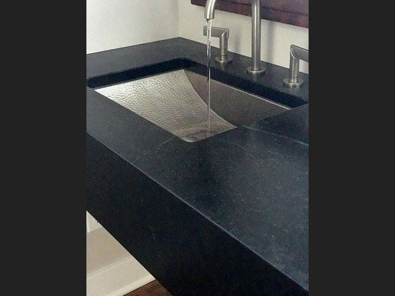 Oiled Black Soapstone bathroom counter with a hammered metal sink.
