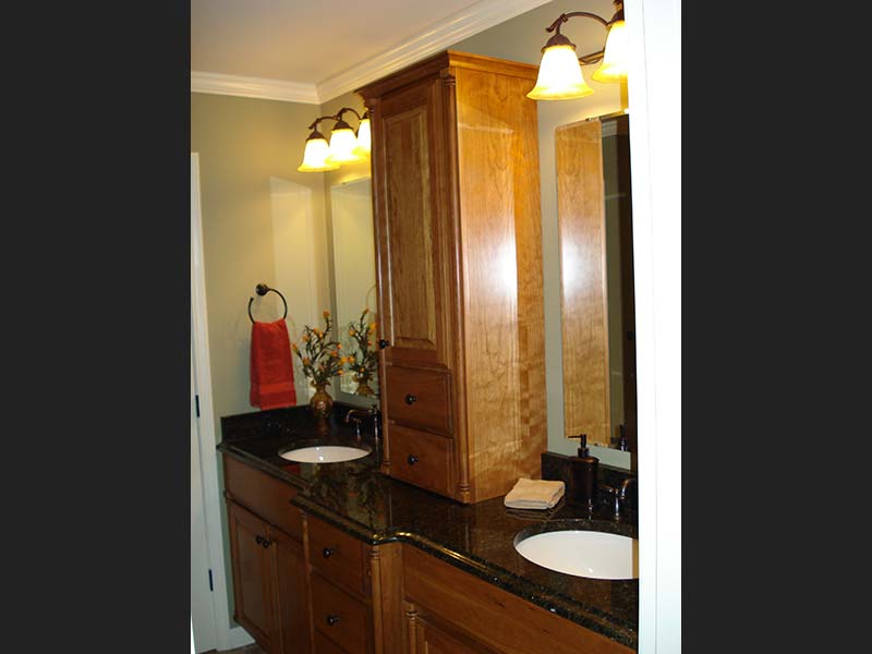 Uba Tuba Granite counter with double sinks shines agains medium-dark wood toned cabinets.