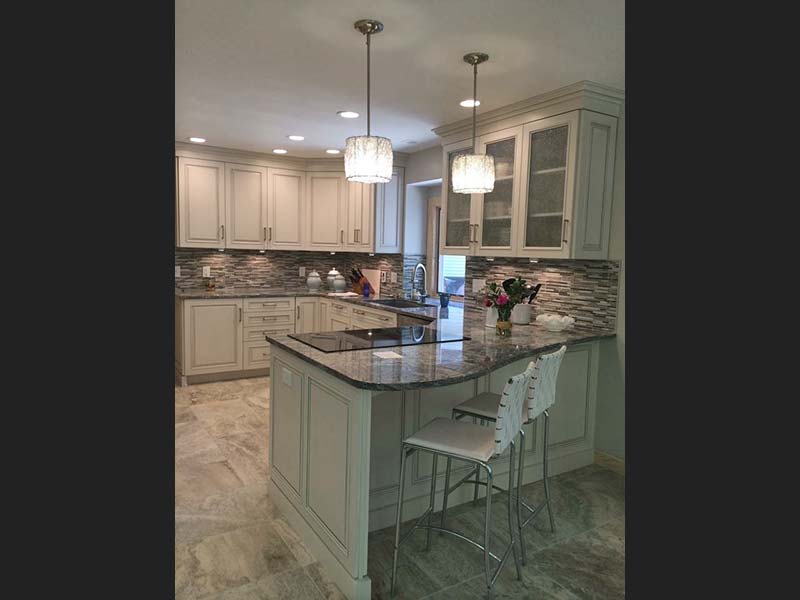 Diamond Wave Granite accentuates this counter top range surrounded by white cabinets and a neutral backsplash.