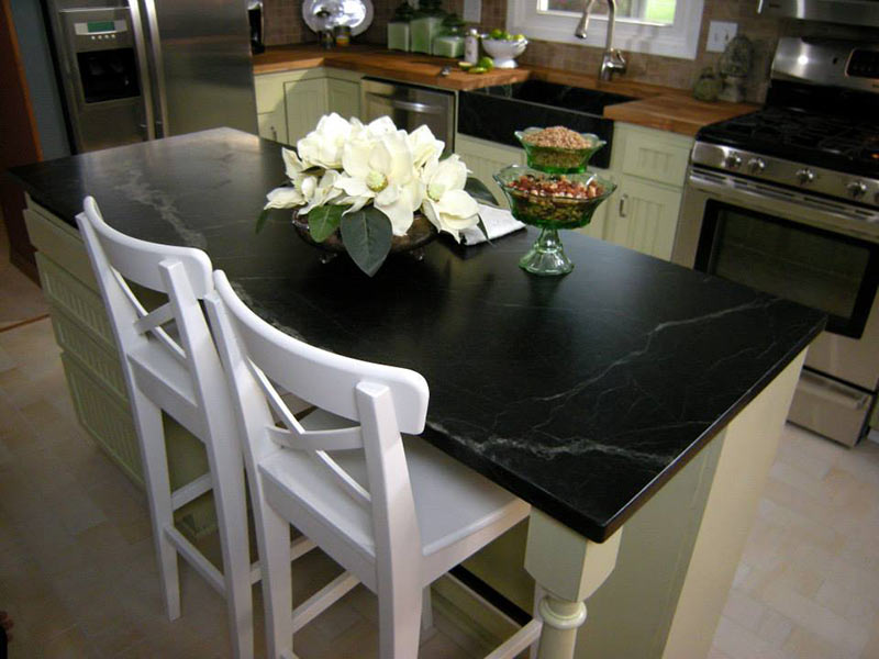 Oiled Black Soapstone playing up the contrast against white cabinets and chairs.