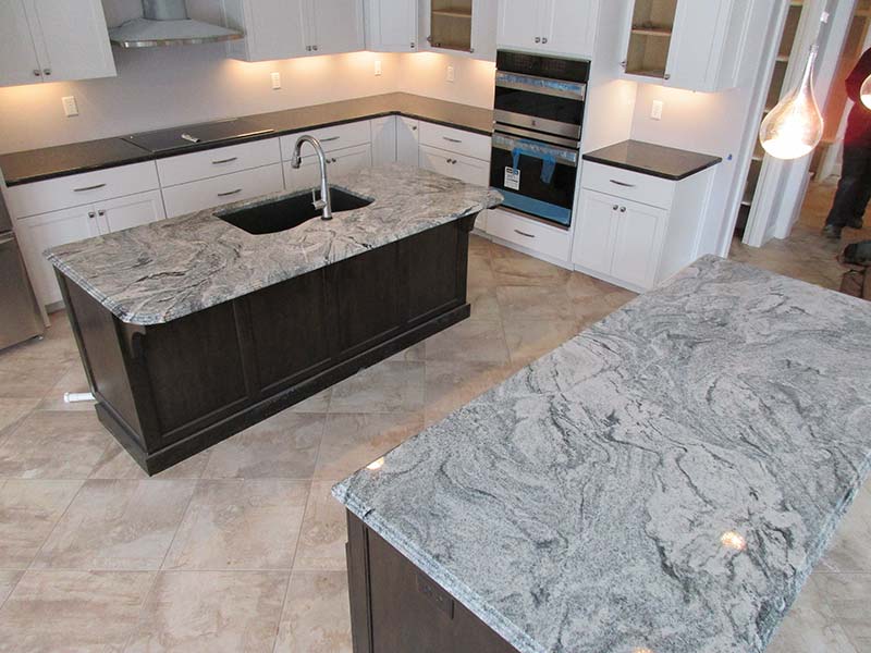 Viscont white Granite kitchen islands contrasting with dark granite counters.